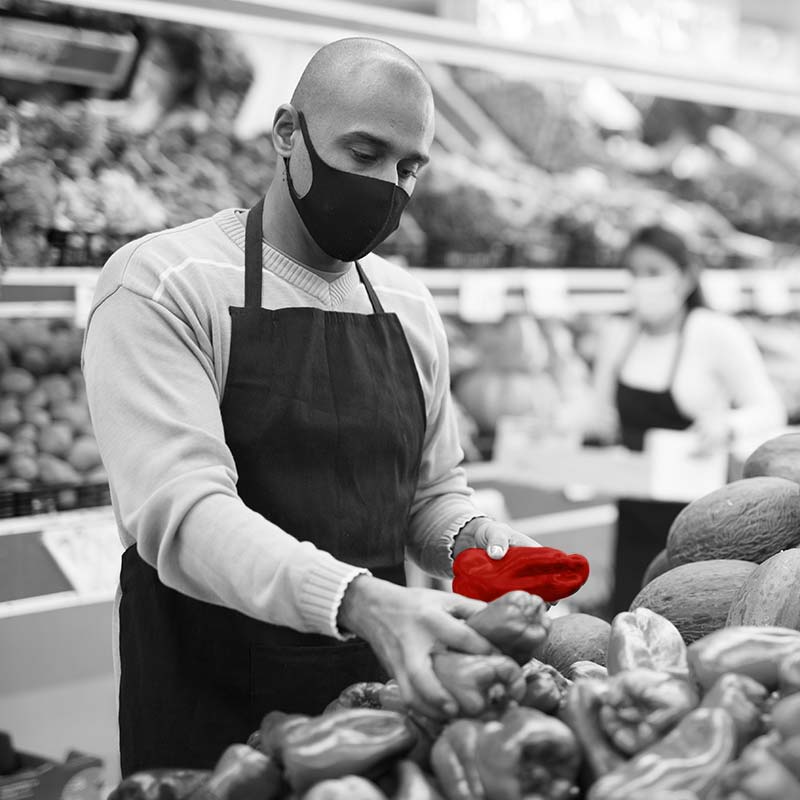 Grocery worker stocking bell peppers