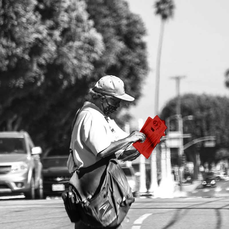 Mail carrier walking across street