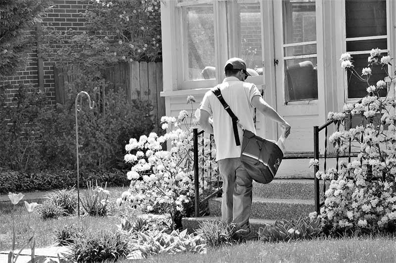 Mailman delivering mail to a house