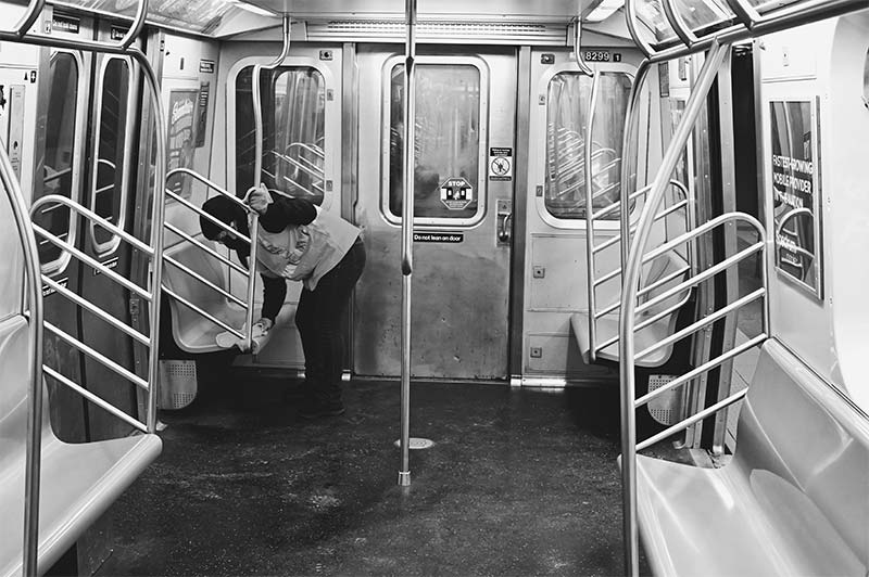 Transit worker disinfecting subway seats